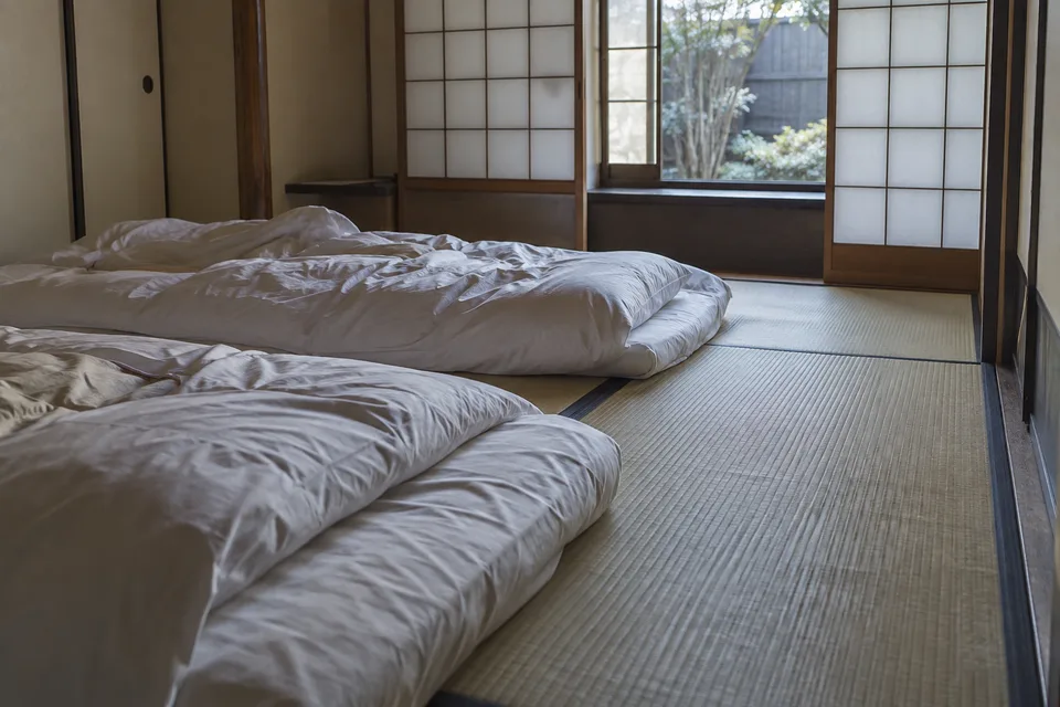 Two futons in soft morning light, with a clear strip of tatami alongside.