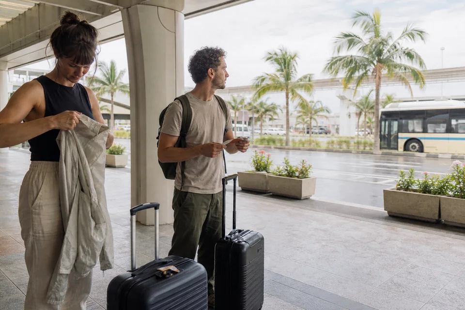 那覇空港: 到着後に紙の住所を見ながら次の交通を相談する旅行者